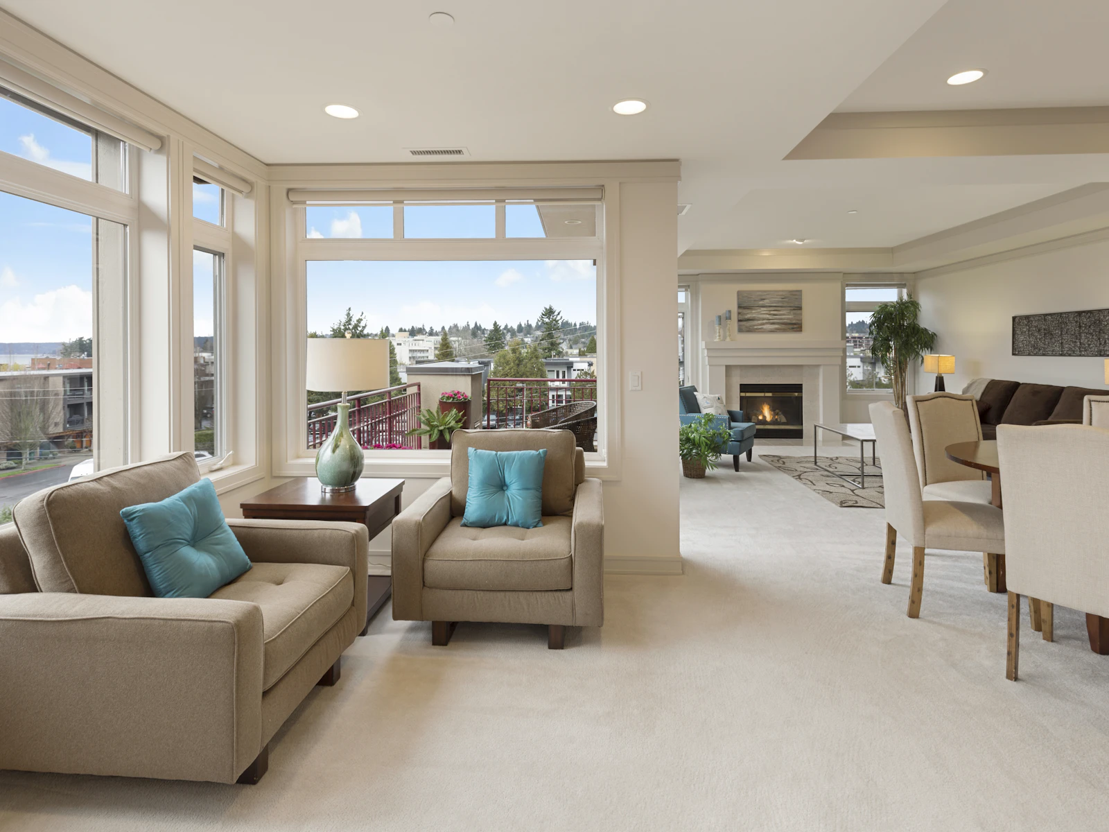 Condo living area with a low sofa, city light, and a pale floor.